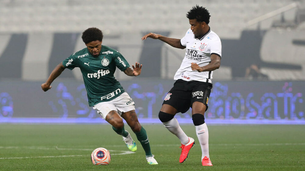 O jogador Luiz Adriano, da SE Palmeiras, disputa bola com o jogador Gil, da SC Corinthians P, durante partida válida pela final, ida, do Campeonato Paulista, Série A1, na Arena Corinthians.