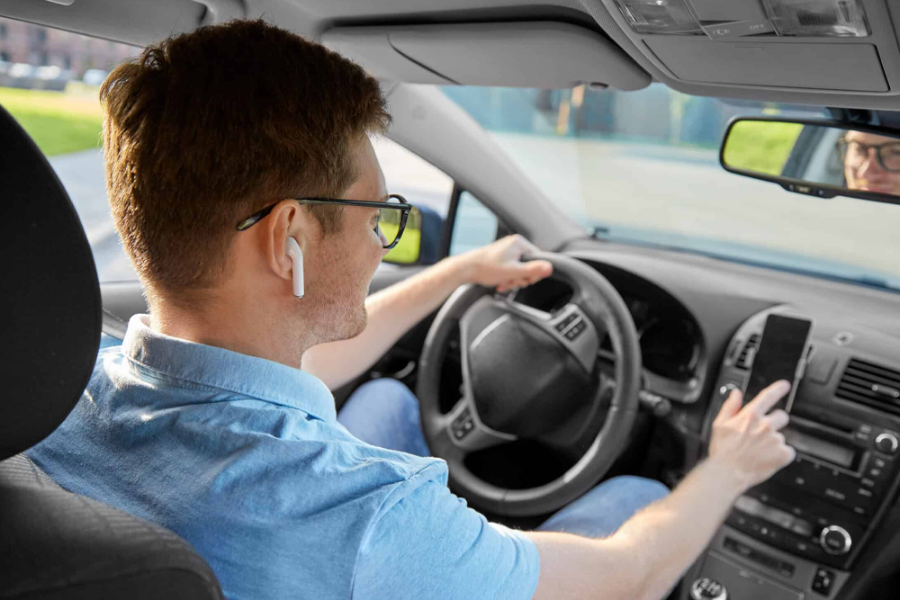 Motorista de carro usando fone de ouvido